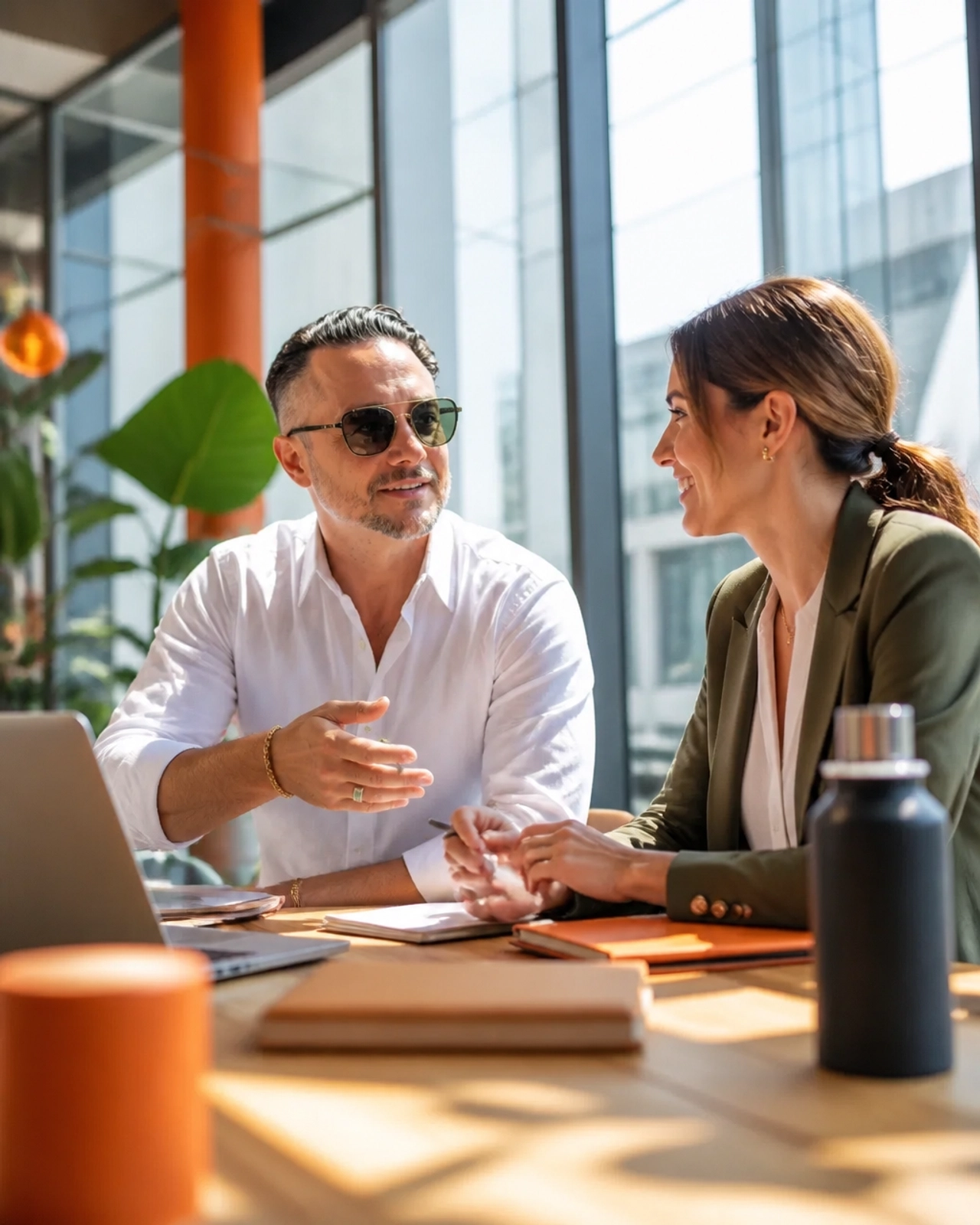 Two professionals in a bright, modern office engaged in a coaching moment, representing high-energy leadership and training.